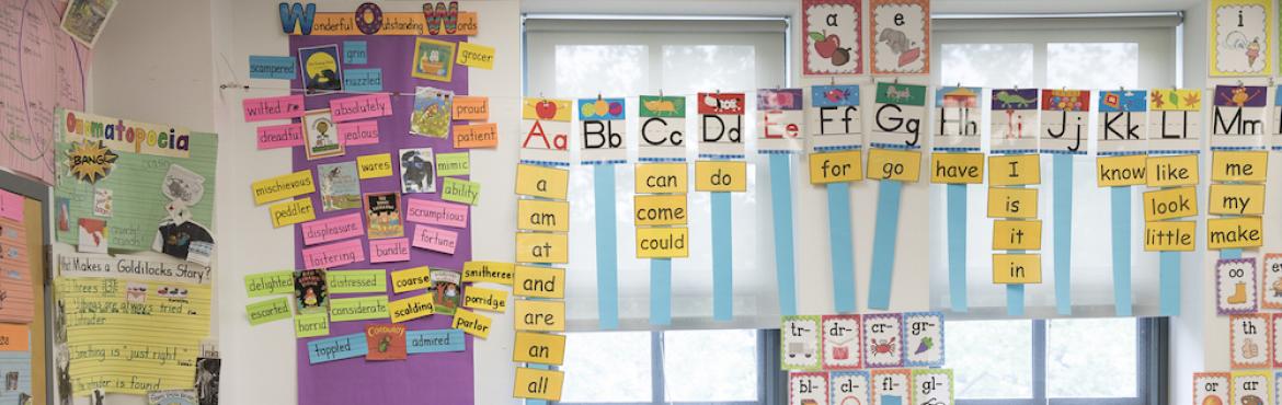  This is a picture of a classroom wall that is filled with anchor charts and student learning materials.